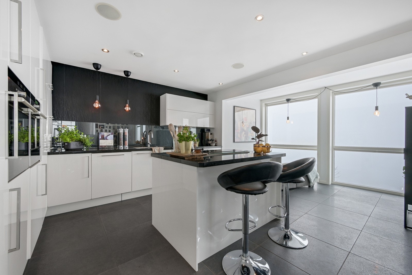 Kjøkkenet fremstår som en eksklusiv oase med øy og benkeplater i granitt Galleribilde