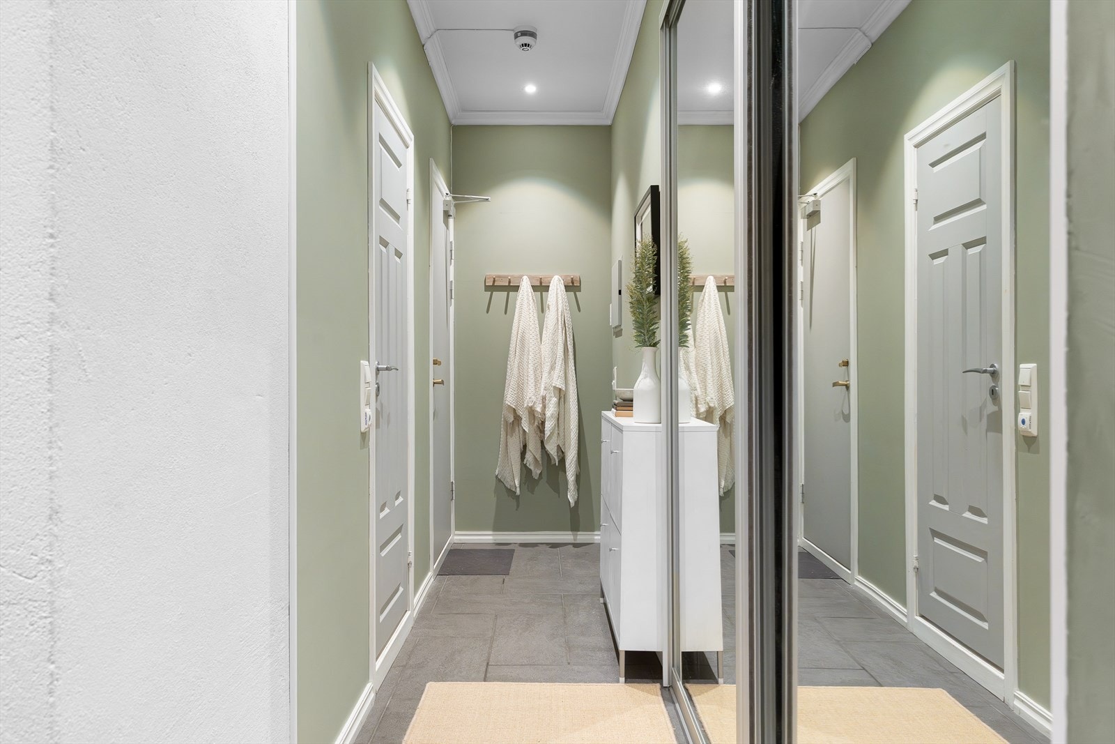 Her får du en stor skyvedørsgarderobe med speildører som gir gode oppbevaringsmuligheter for yttertøy og sko, samtidig som speilflatene bidrar til en romslig følelse. Galleribilde