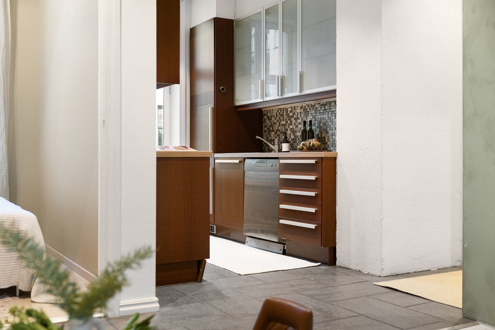 Det delvis separate kjøkkenet har en funksjonell innredning med glatte fronter og laminert benkeplate med nedfelt vaskekum. Her er det også elektriske varmekabler på gulvet. Galleribilde