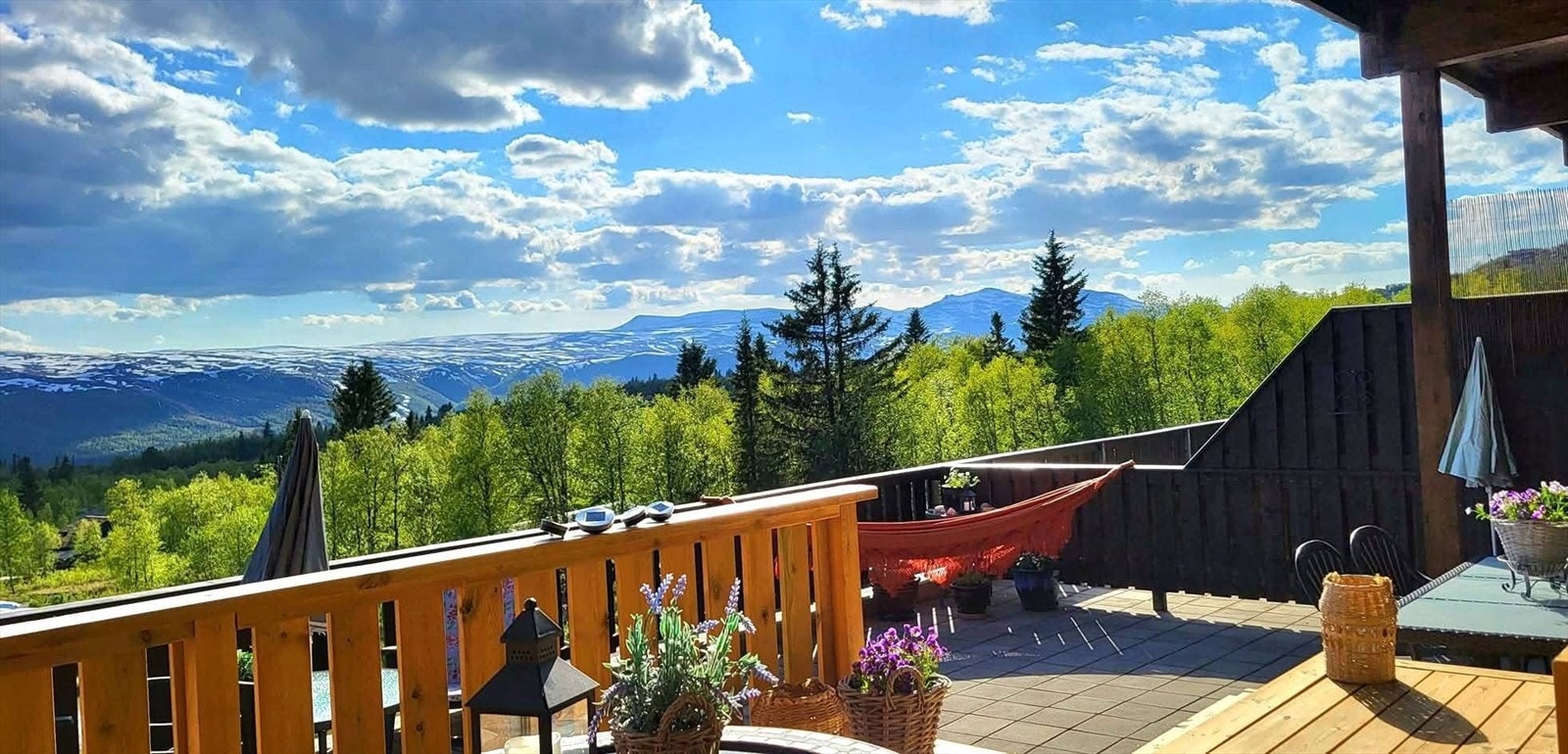 Den plassbygde hjørnesofaen er et godt sted å nyte sol, stillhet og fjellutsikten. Det store takoverbygget gjør at man kan bruke terrassen selv om det kommer regnvær. Galleribilde