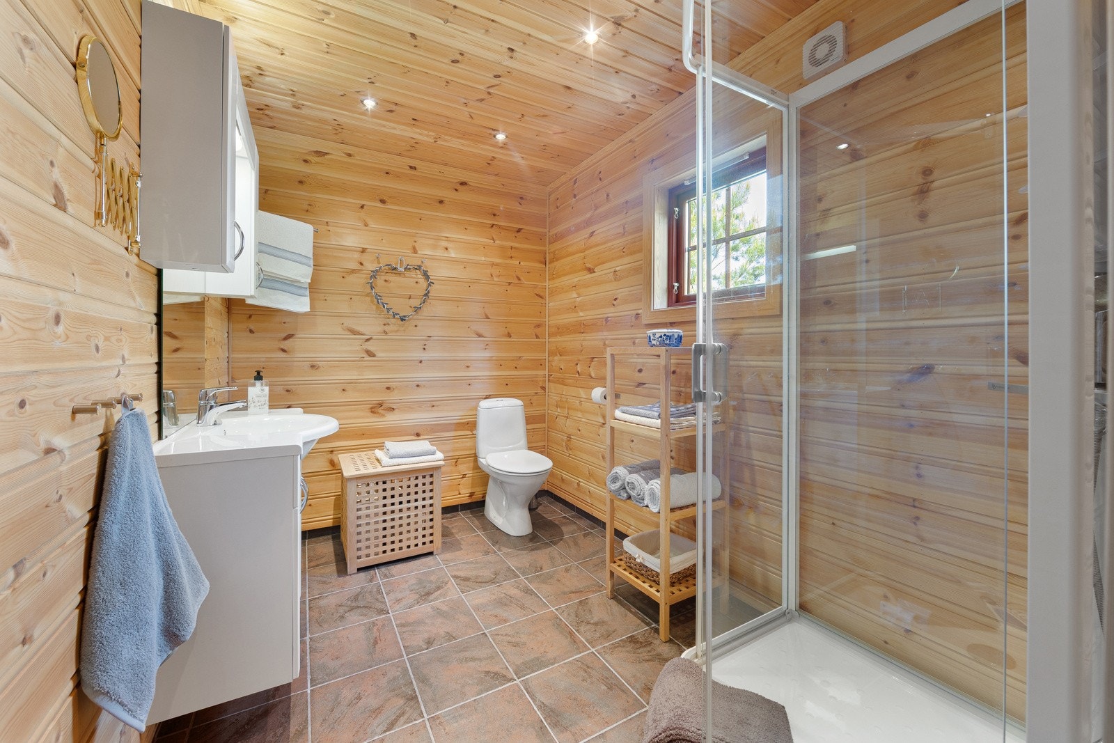 Badet med innredning som inkluderer nedfelt servant, toalett og dusjkabinett. Galleribilde