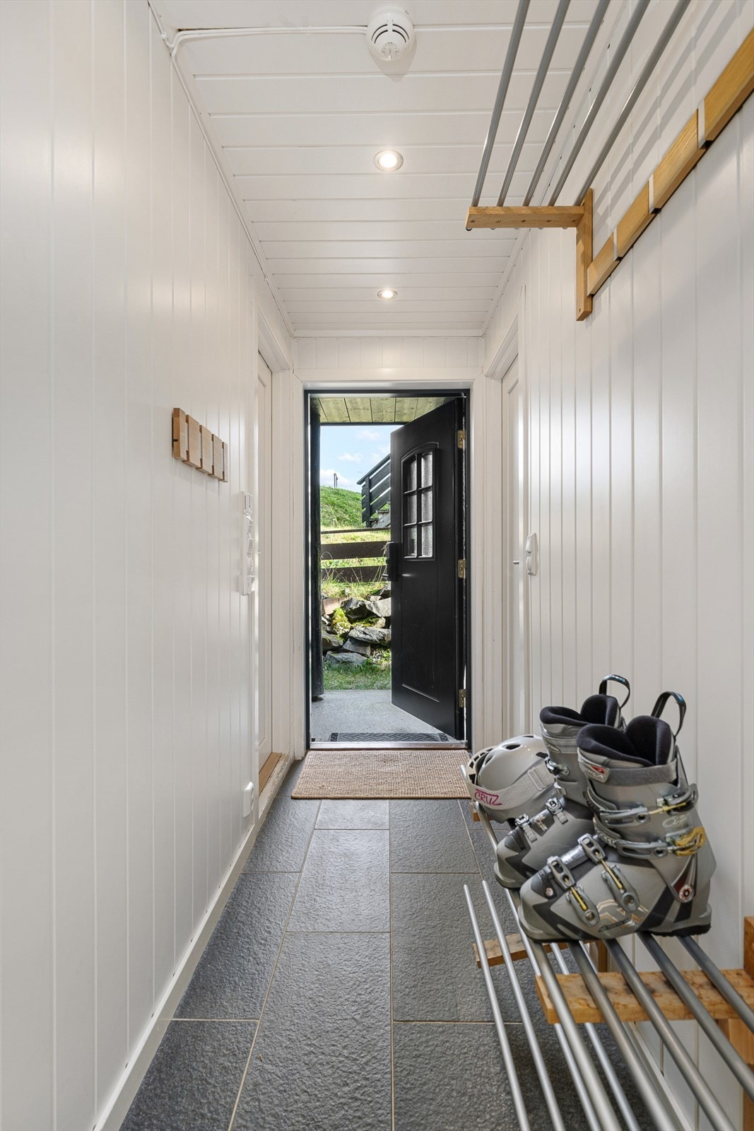 Du ønskes velkommen inn i en hyggelig flislagt entrè med hvitmalte overflater og downlights Galleribilde