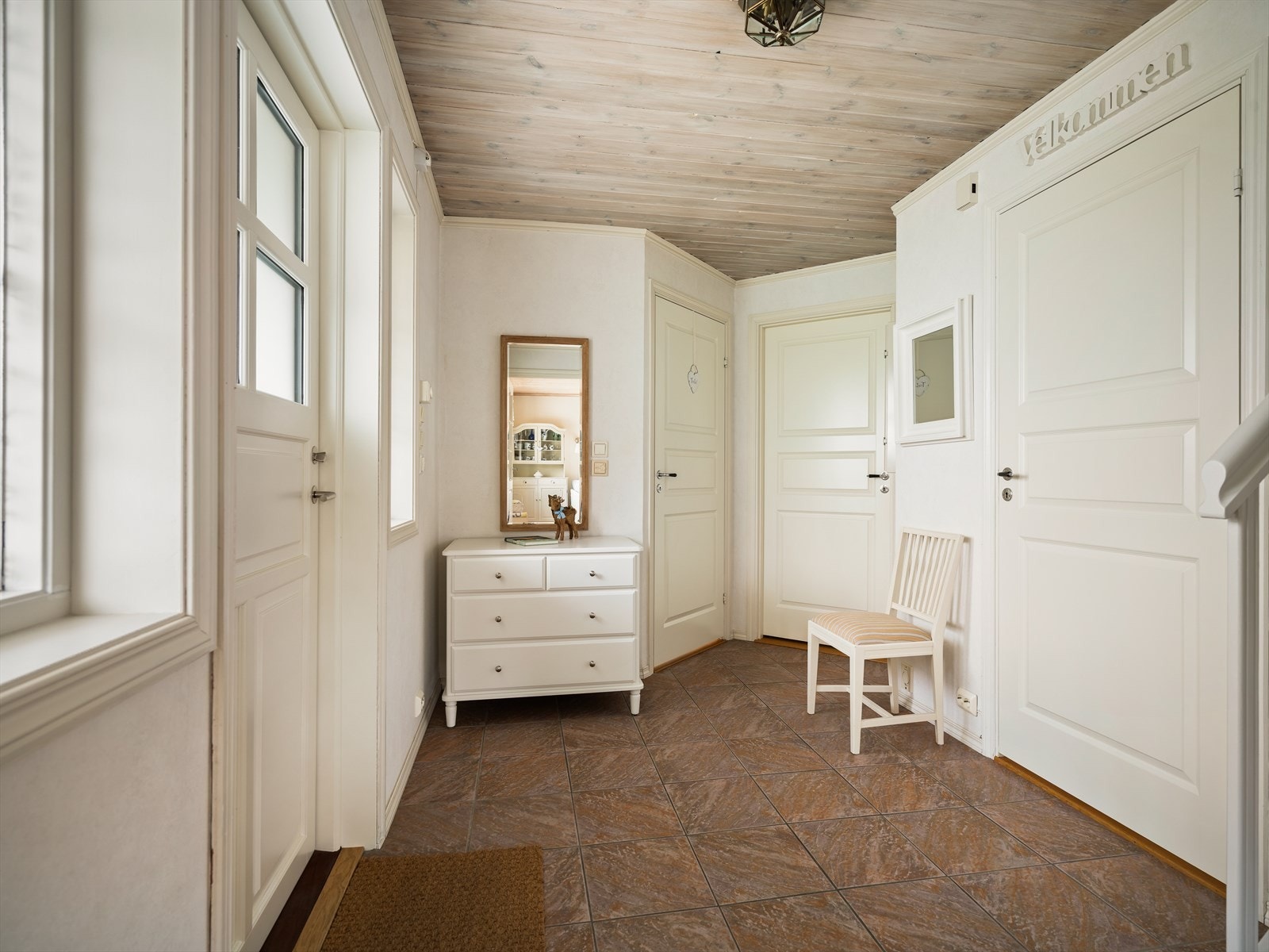 Hyggelig entré med flislagt gulv med gulvvarme og panelte overflater. Galleribilde