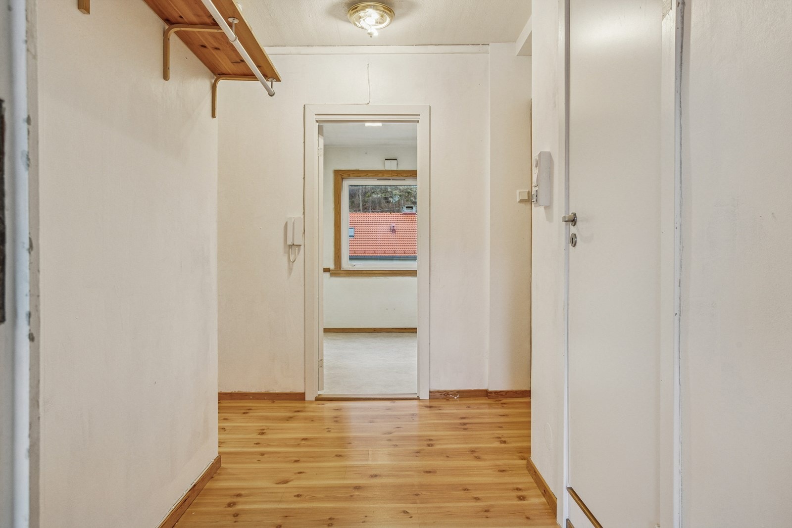 Romslig gang på ca. 5,5 m² med adkomst til kjøkken, bad, stue og ett av soverommene Galleribilde