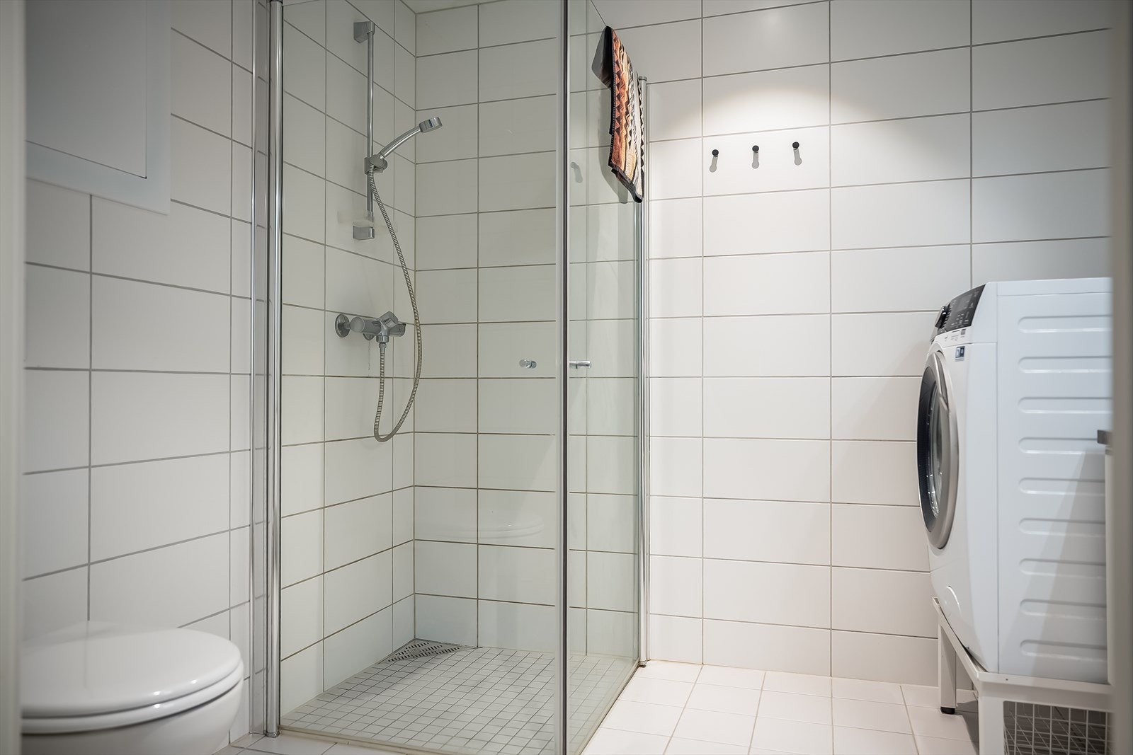 Boligen har flislagt bad på 5 kvm, med opplegg for vaskemaskin, romslig dusj og pen baderomsinnredning. Galleribilde