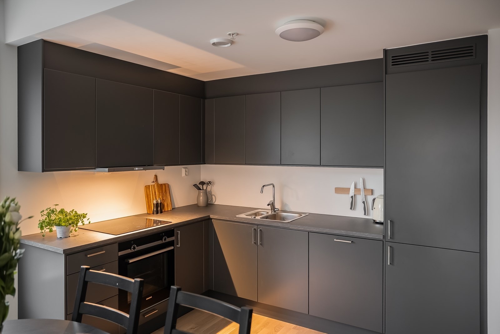 Her får du slette overflater i sort utførelse, som står fint i kontrast til resten av rommet. Takstmann har vurdert kjøkkenet til TG0 i likhet med resten av boligen. Galleribilde