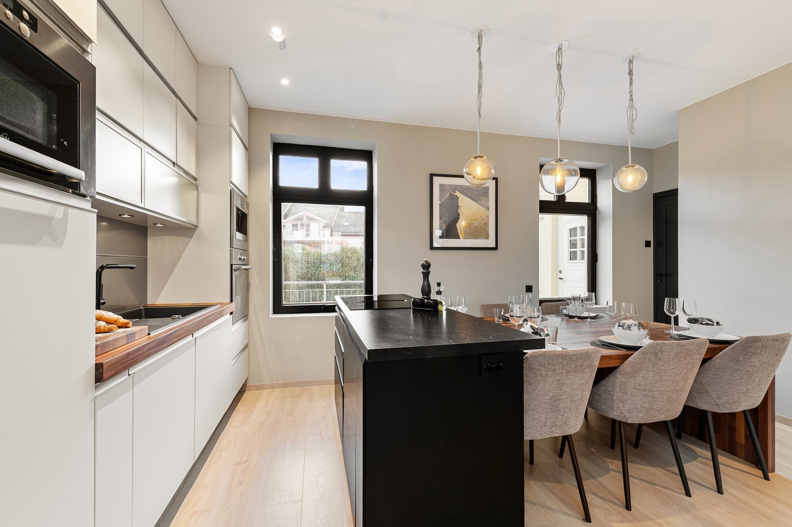 Kjøkkeninnredning fra HTH med integrert kjøleskap, fryser og oppvaskmaskin. Induksjonstopp med kullfilterventilator samt integrert kaffemaskin, mikrobølgeovn og stekeovn. Kjøleskap, fryser, oppvaskmaskin, platetopp og kjøkkenøy fra IKEA er alt fra 2024 Galleribilde