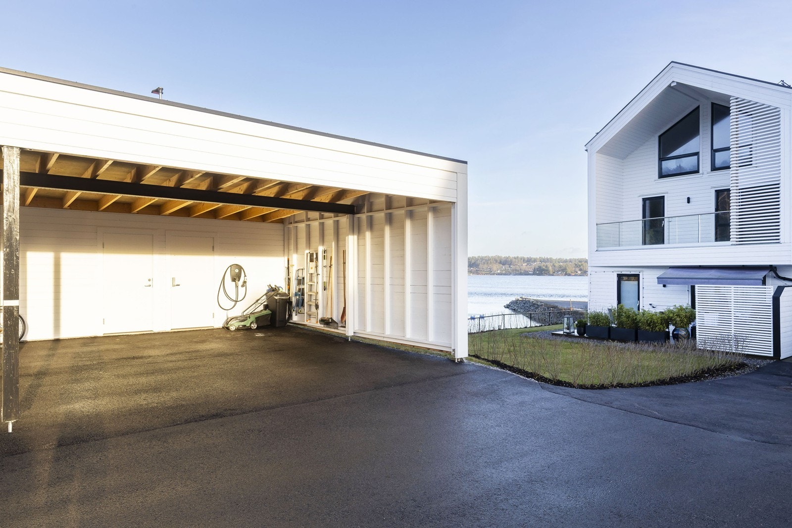 Carport med bod i bakkant og el-bil lader Galleribilde