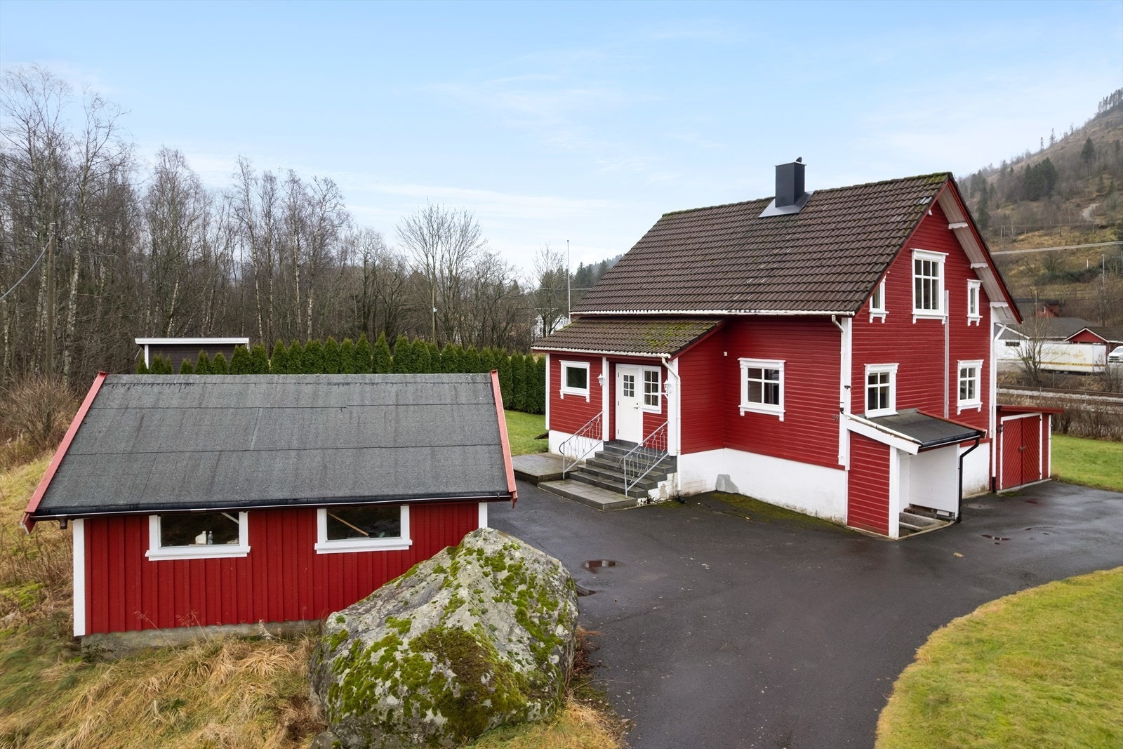 Tomten er pent opparbeidet med både asfalt og plen, og her er det gode parkeringsmuligheter, enten i garasje, carport eller på egen gårdsplass. Galleribilde