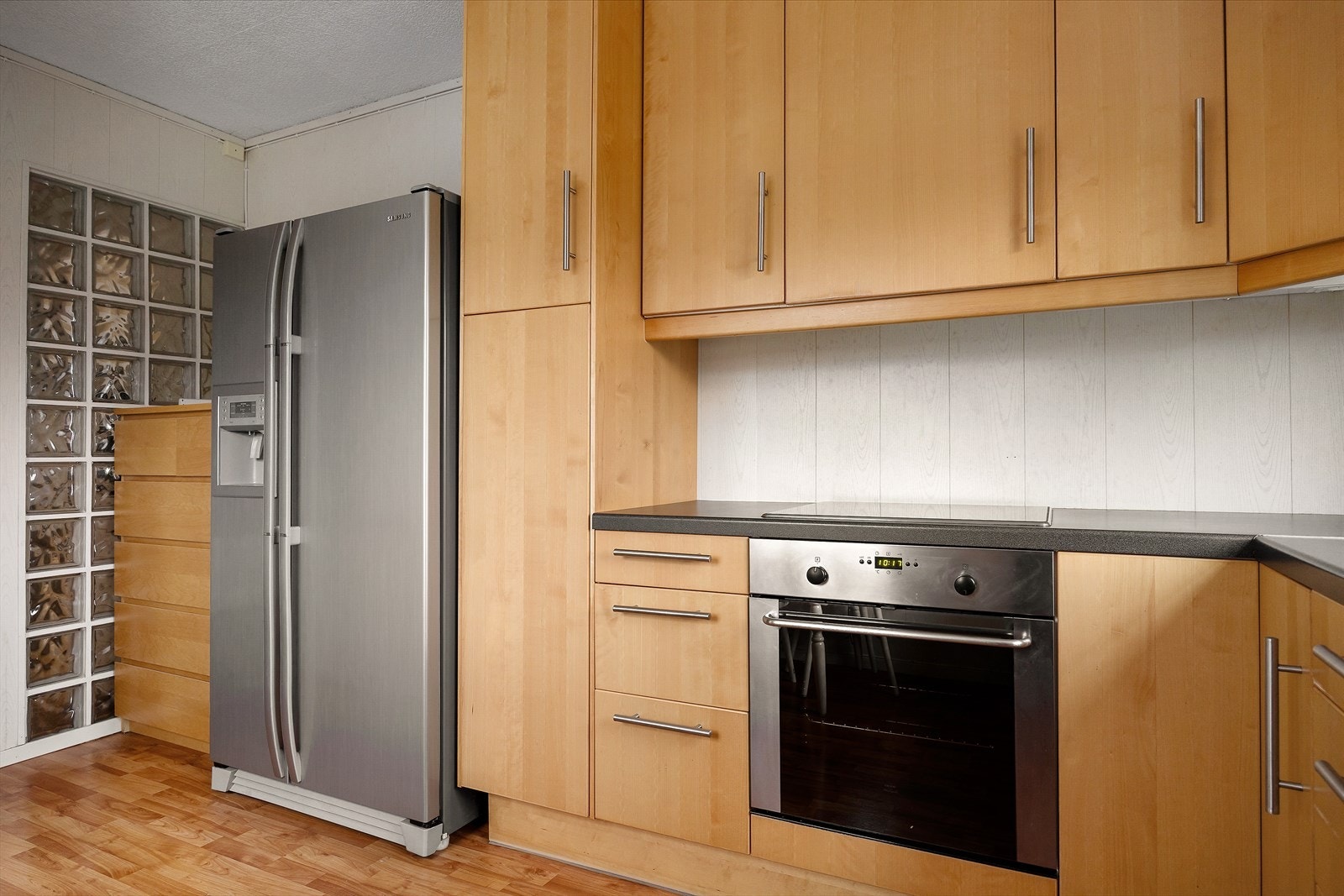 Kjøkkenet er funksjonelt innredet med slette fronter og laminat benkeplate med nedfelt vask. Her er det integrerte hvitevarer som følger handelen. Kjøkkenet har godt med skap- og benkeplass, perfekt for matlaging. Galleribilde