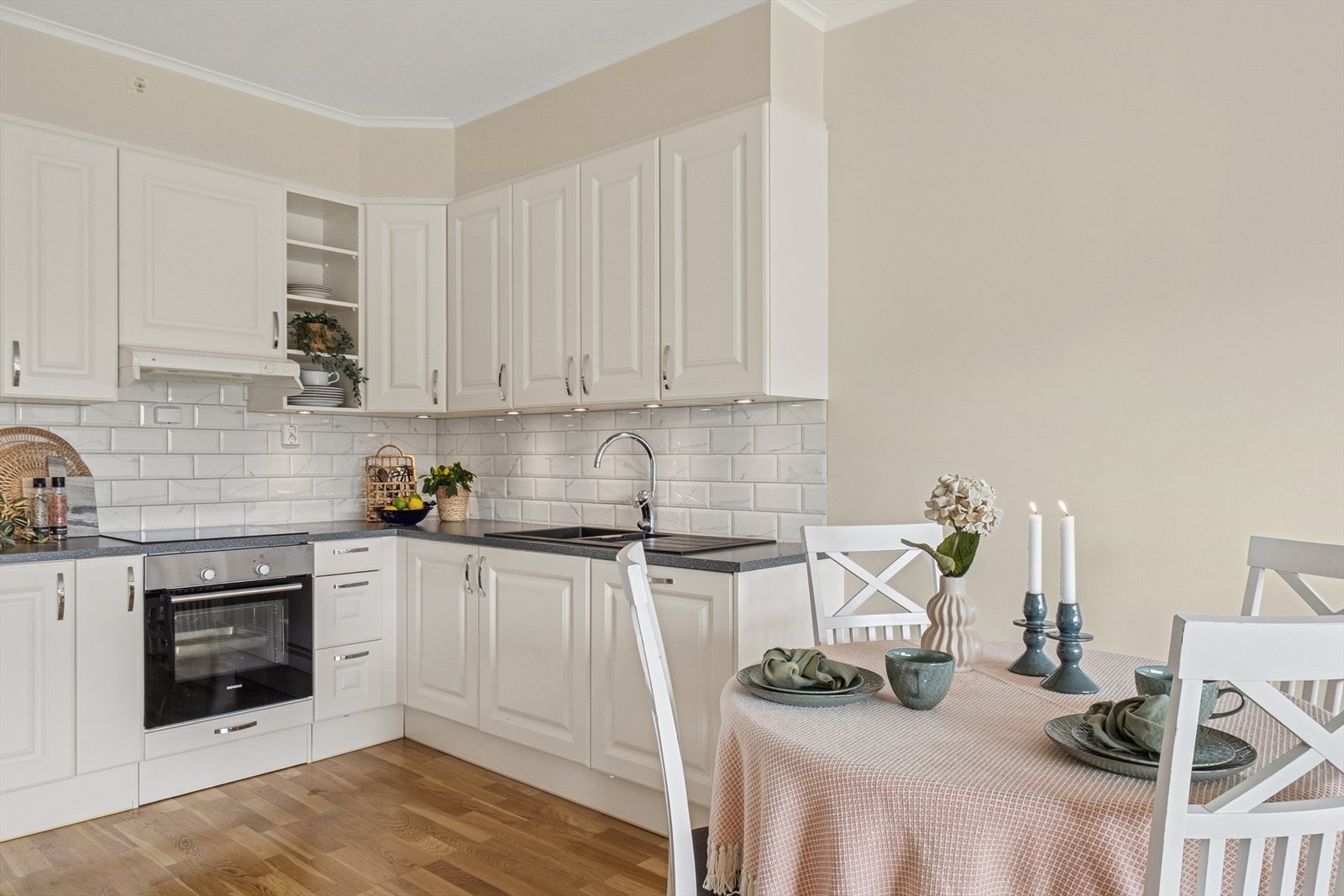 Kjøkkenet ligger i en åpen og sosial løsning mot stuen, noe som gir en god romfølelse og naturlig flyt i boligen. Innredningen er fra byggeåret og består av folierte fronter, skrog og benkeplate, med fliser over benken som gir et rent og klassisk uttrykk. Galleribilde