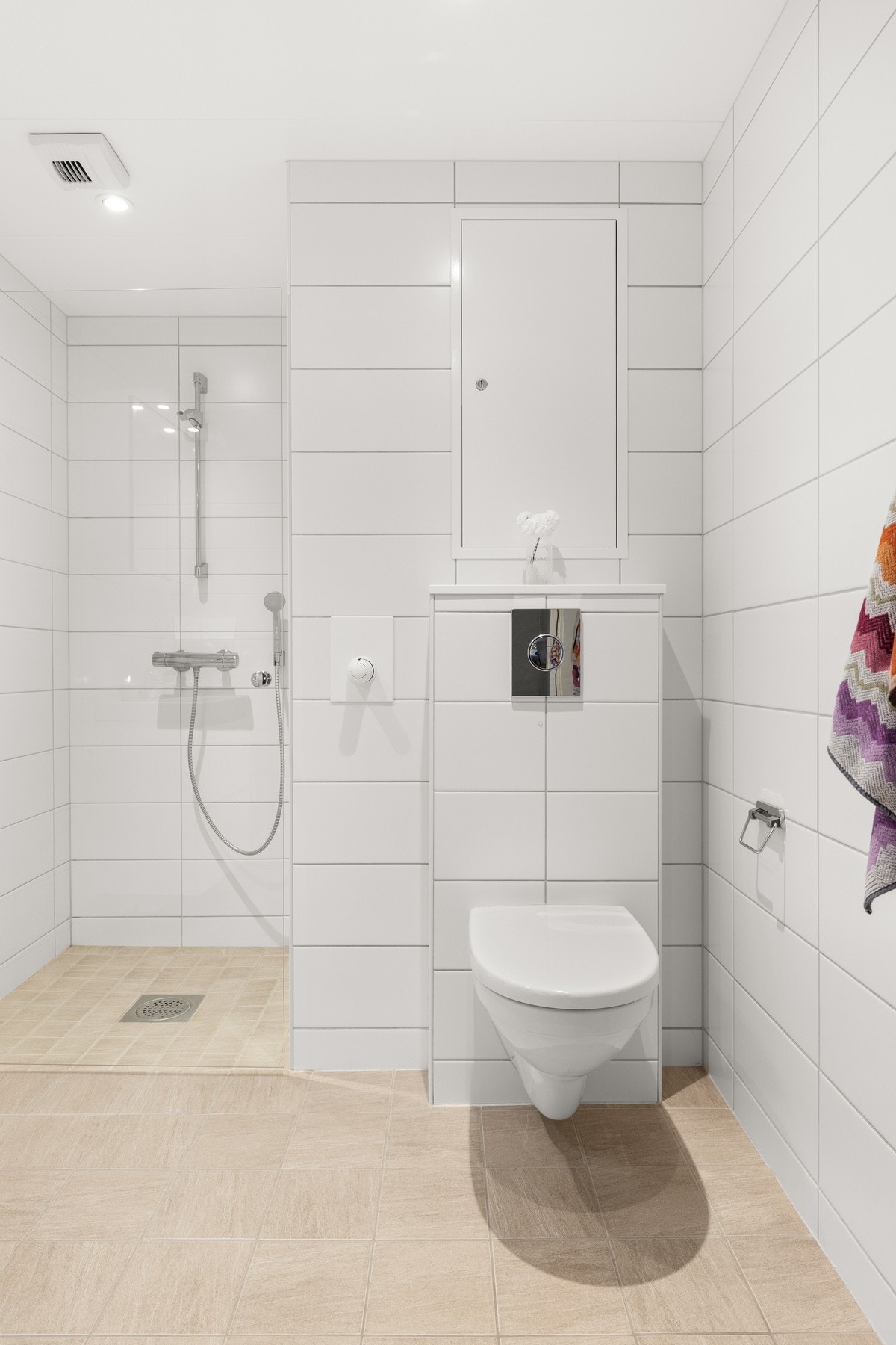 Vegghengt toalett i hvit porselen med to-trinns vannspyling og innebygget sisterne. Galleribilde