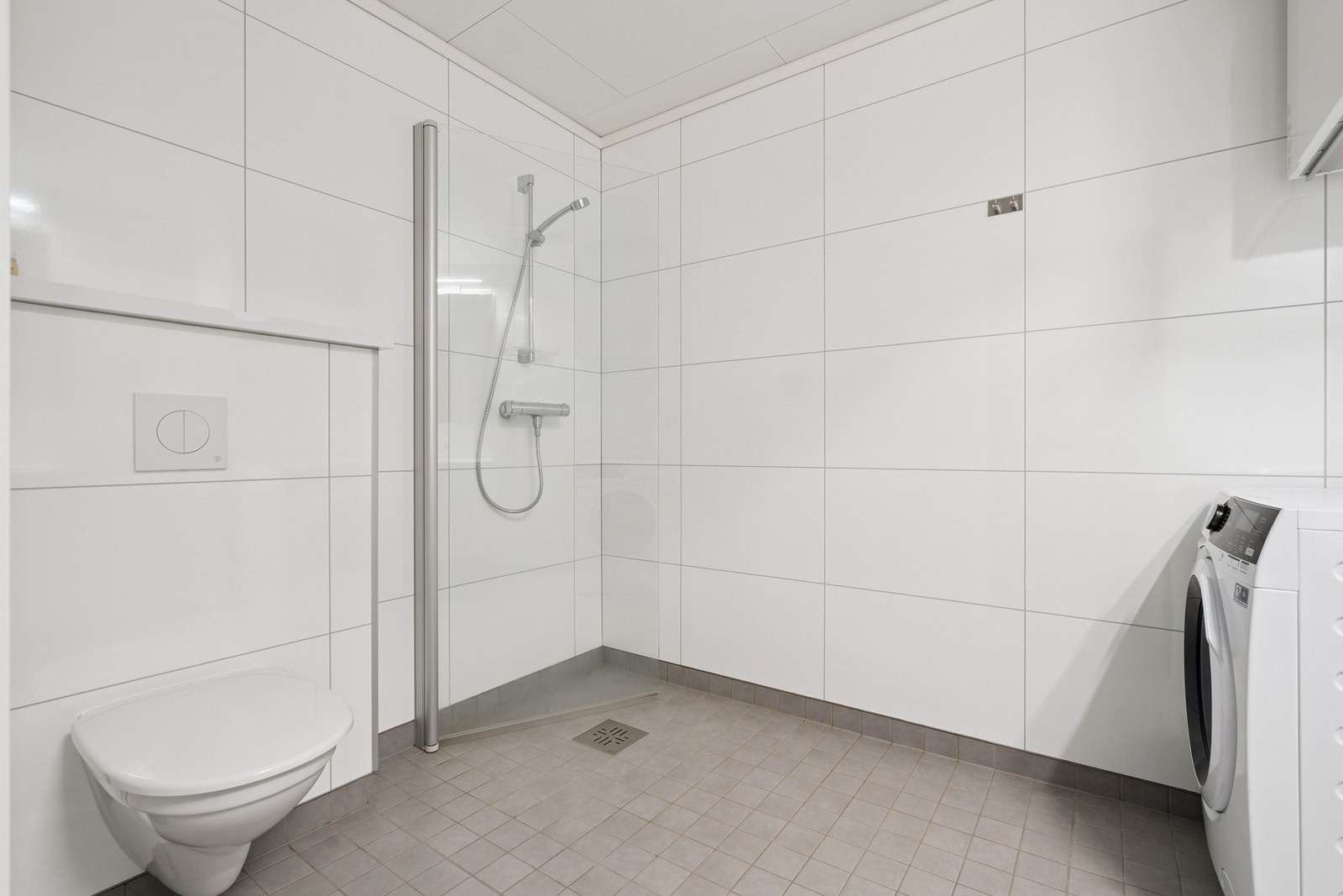 Romslig bad med våtromsplater på vegger og fliser med elektriske varmekabler på gulvet. Galleribilde