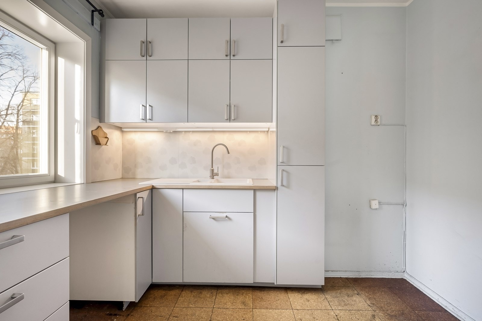 Kjøkkeninnredningen har glatte fronter, laminatbenkeplate og er utstyrt med komfyrvakt. Galleribilde