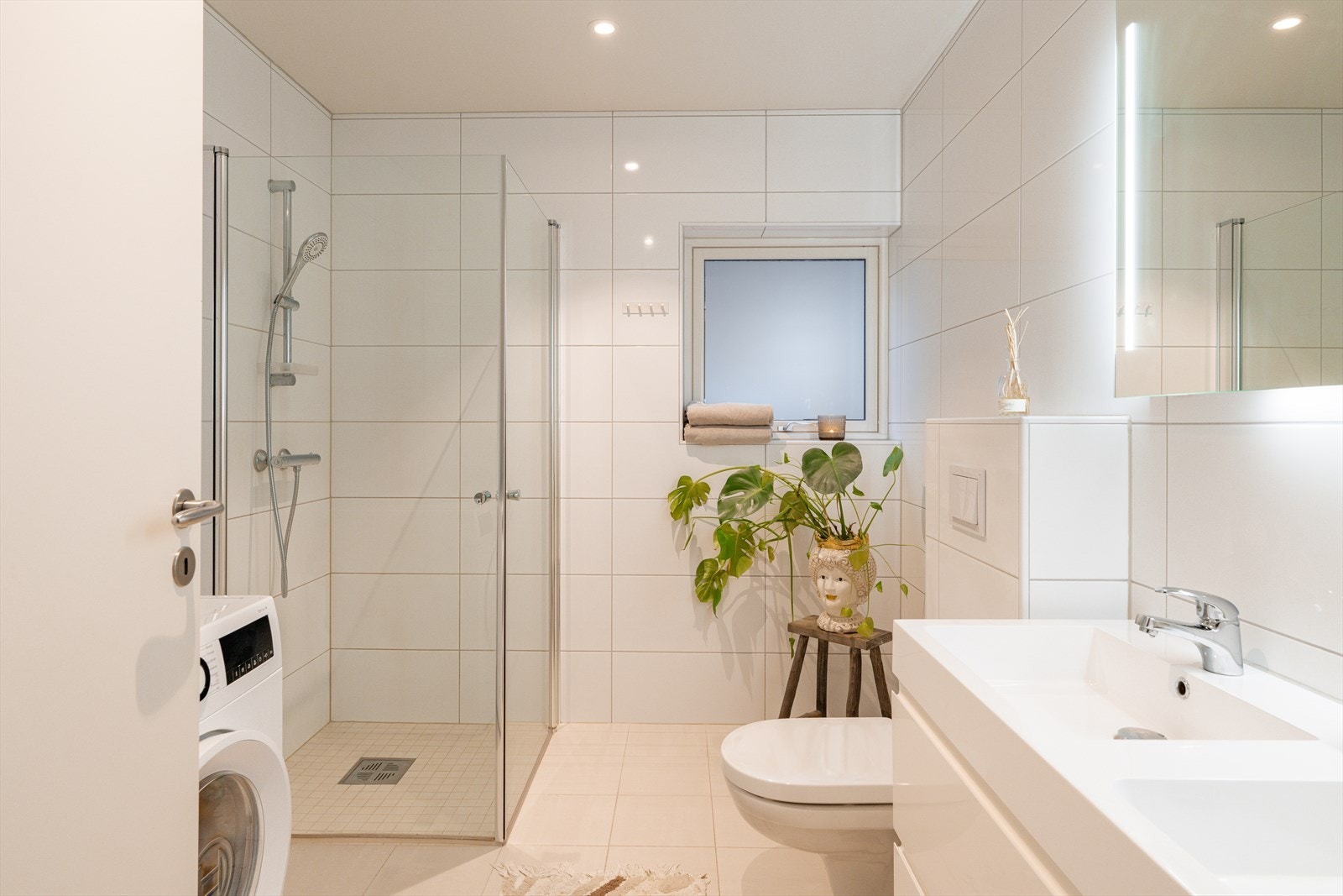 Plasseffektivt bad med innfellbar dusjløsning og vaskemaskin. Galleribilde