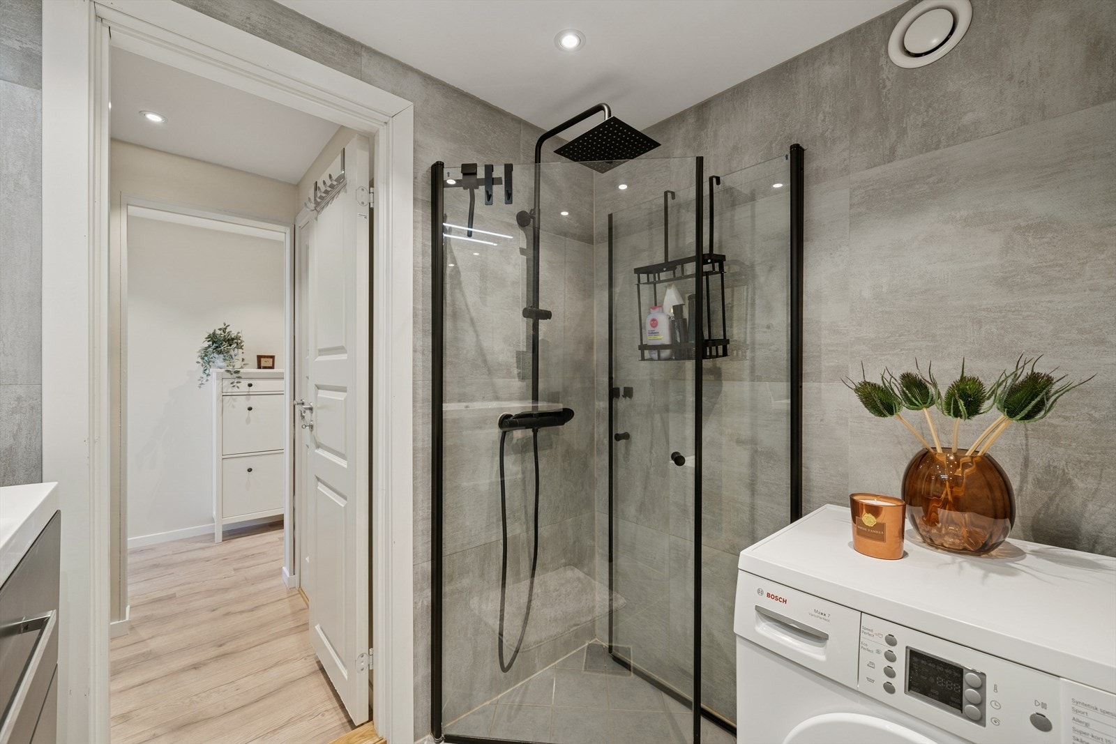 Badet fremstår som moderne og delikat, med lyse fliser og en tidløs utforming. Galleribilde