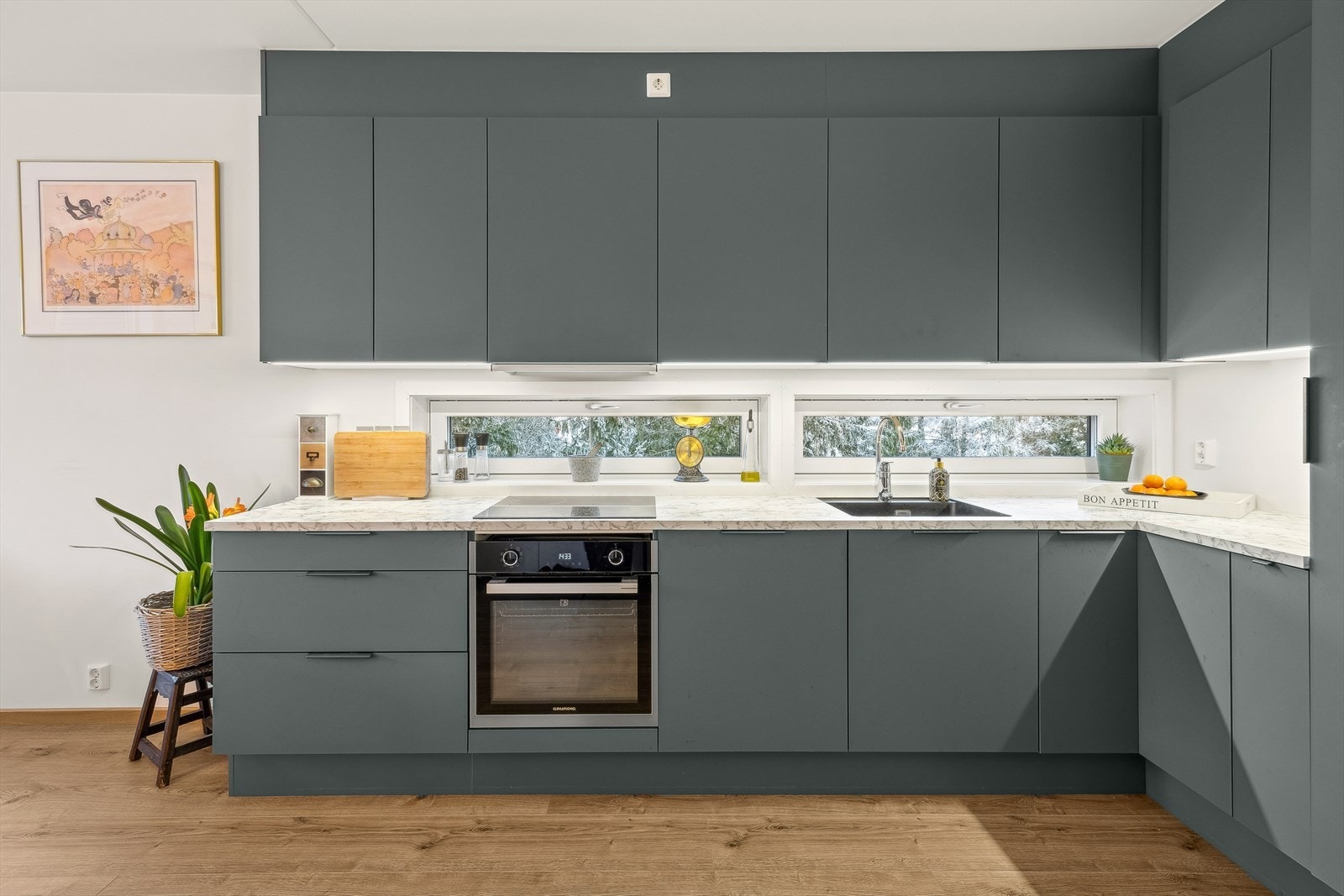 Kjøkkenet har blant annet laminert benkeplate og planlimt kjøkkenkum i svart kompositt Galleribilde