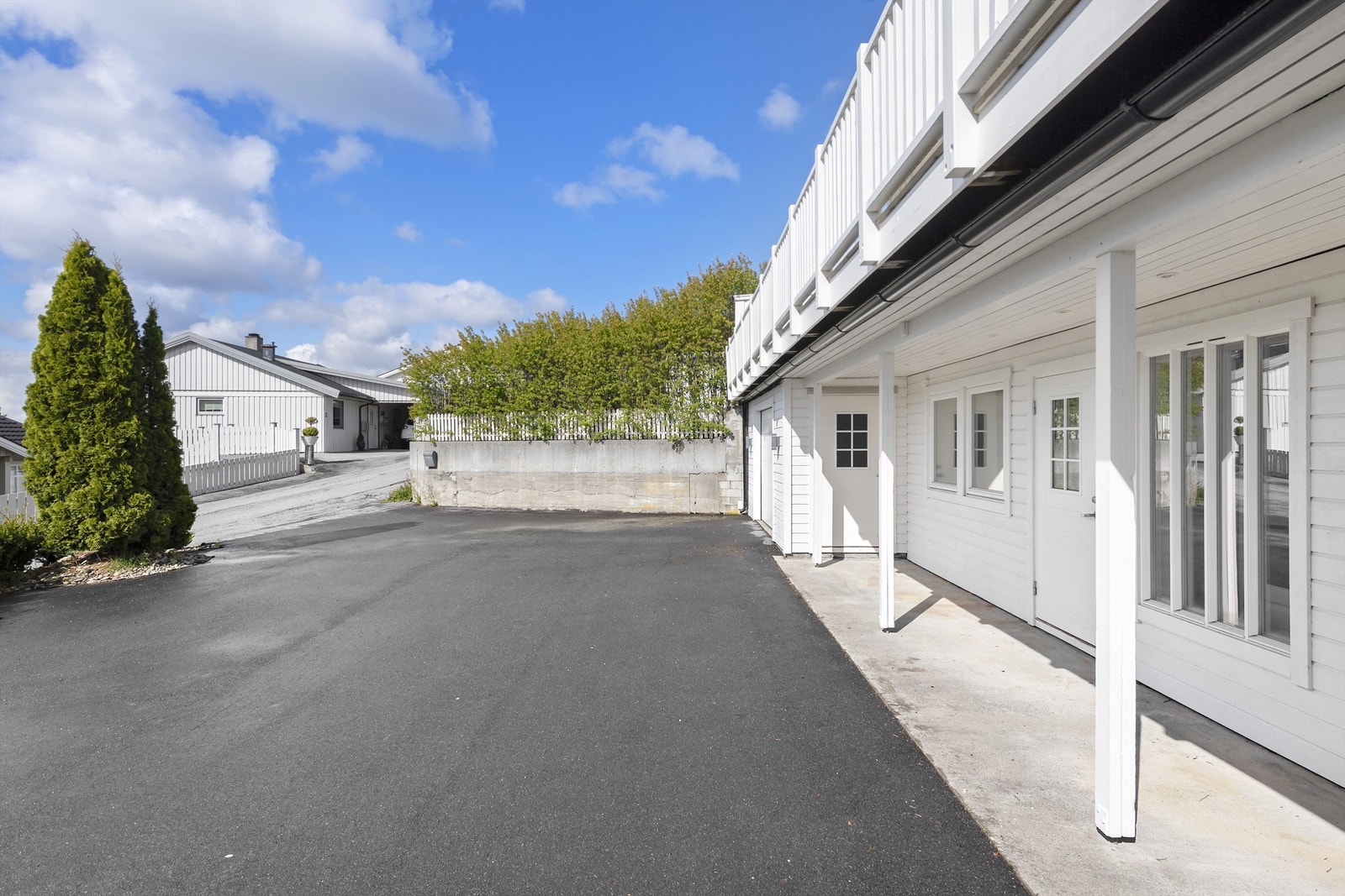 Inngangsparti og asfaltert gårdsplass Galleribilde