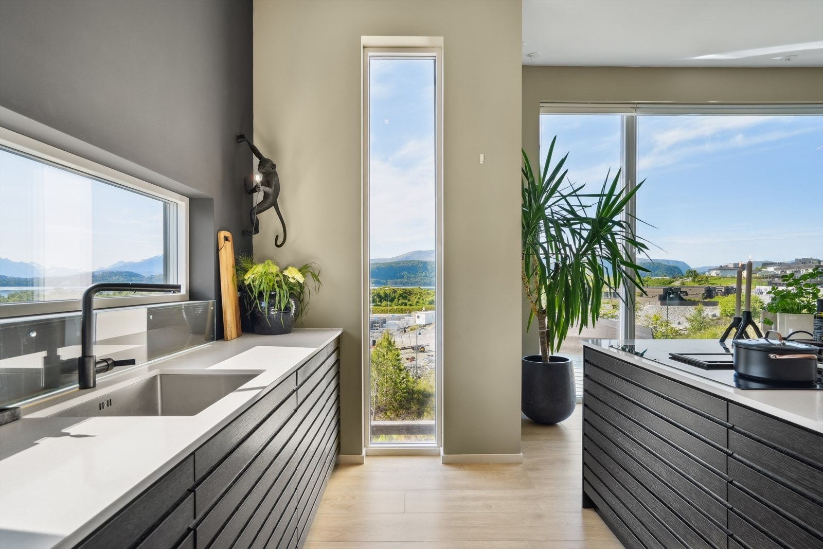 Kjøkkenet er innbydende med mørke fronter og benkeplate av stein Galleribilde