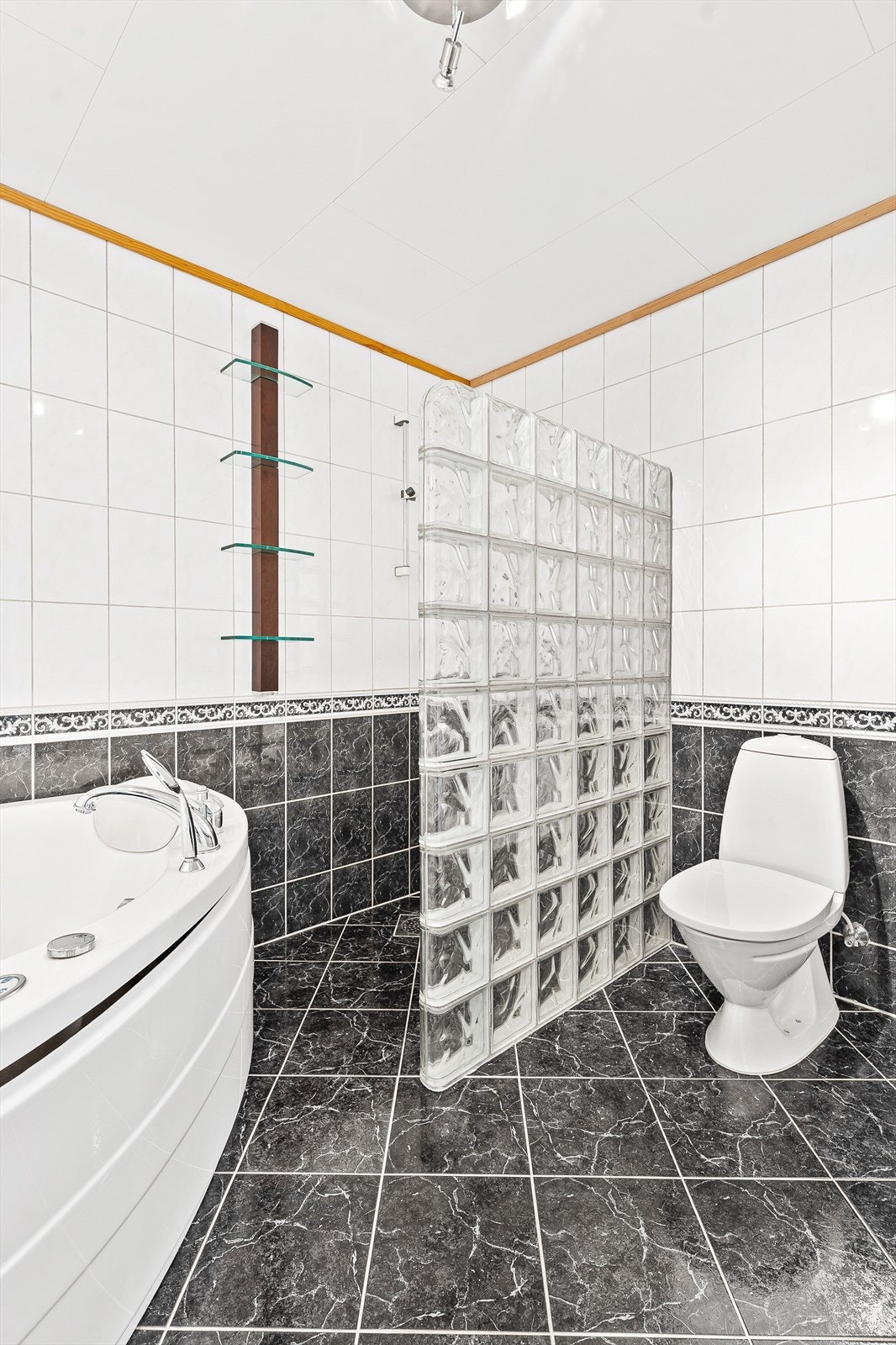 Rommet er innredet med nedfelt servant, badekar, dusjhjørne og toalett Galleribilde