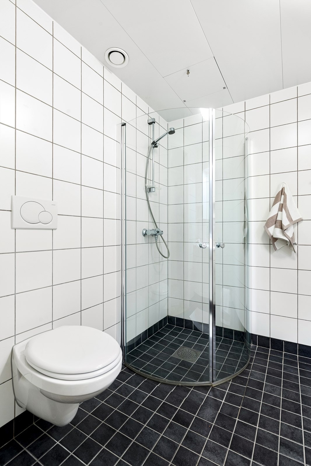 Badet er utstyrt med servant med underskap, speil, veggskap, dusjnisje med innfellbare dører og toalett Galleribilde