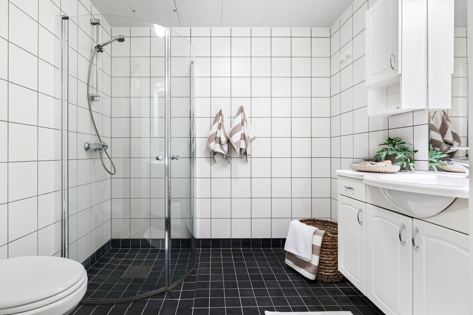 Romslig bad med flislagte overflater og behagelige varmekabler i gulv Galleribilde