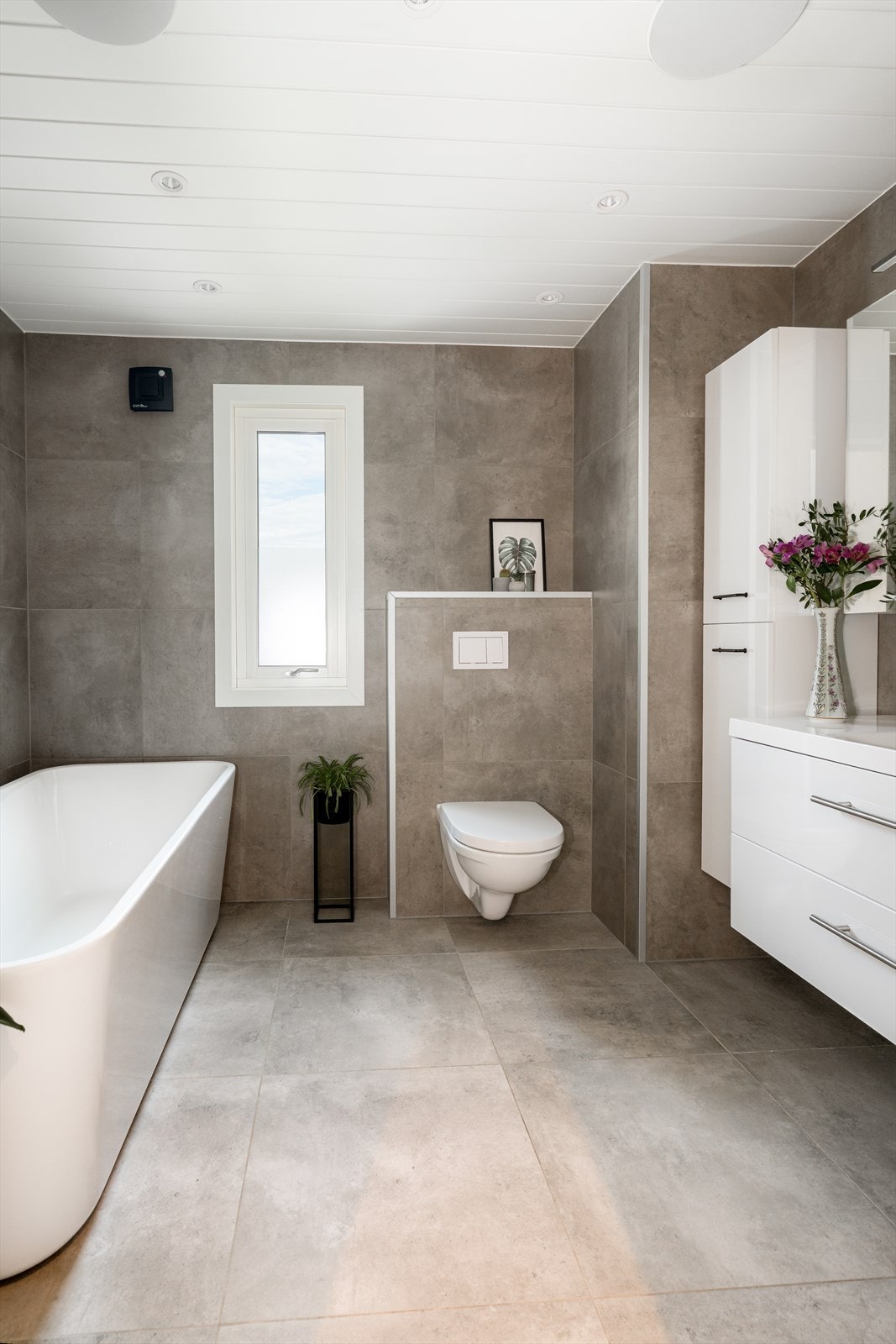 Pent bad fra 2021 med overflater som består av 60x60 flis på gulv samt vegg og mdf- panel i himling med LED downlights.1 Galleribilde