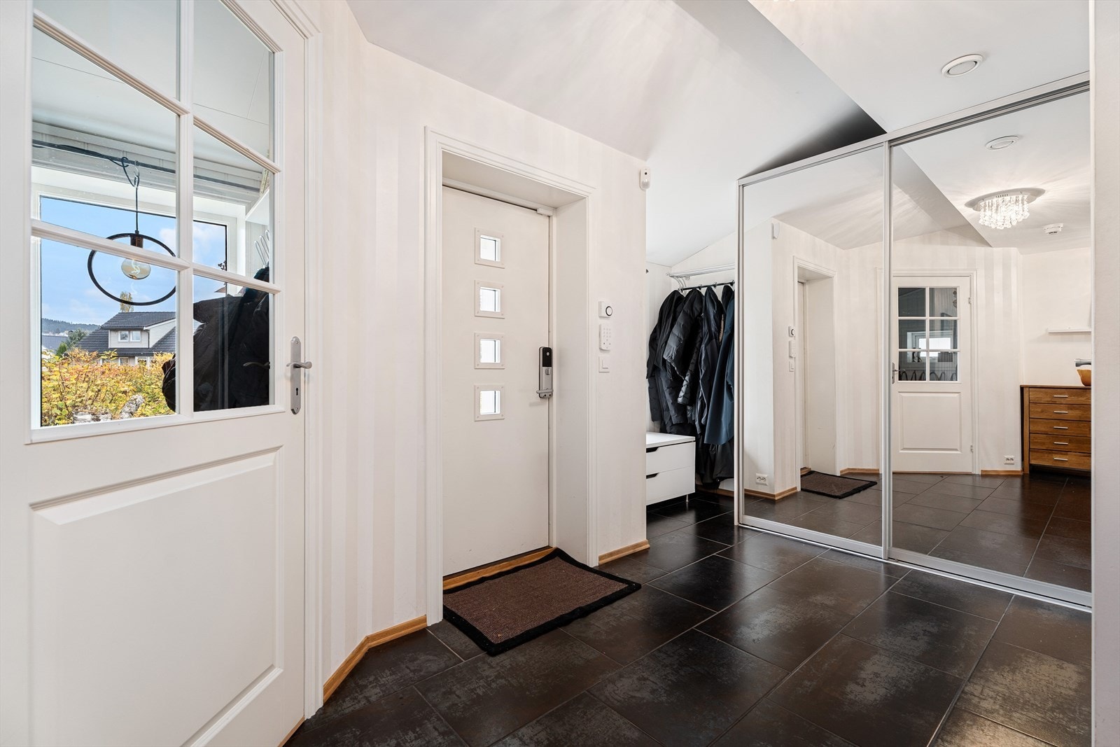 Romslig entre, som har fliser på gulv med varme. Praktisk skyvedørsgarderobe Galleribilde