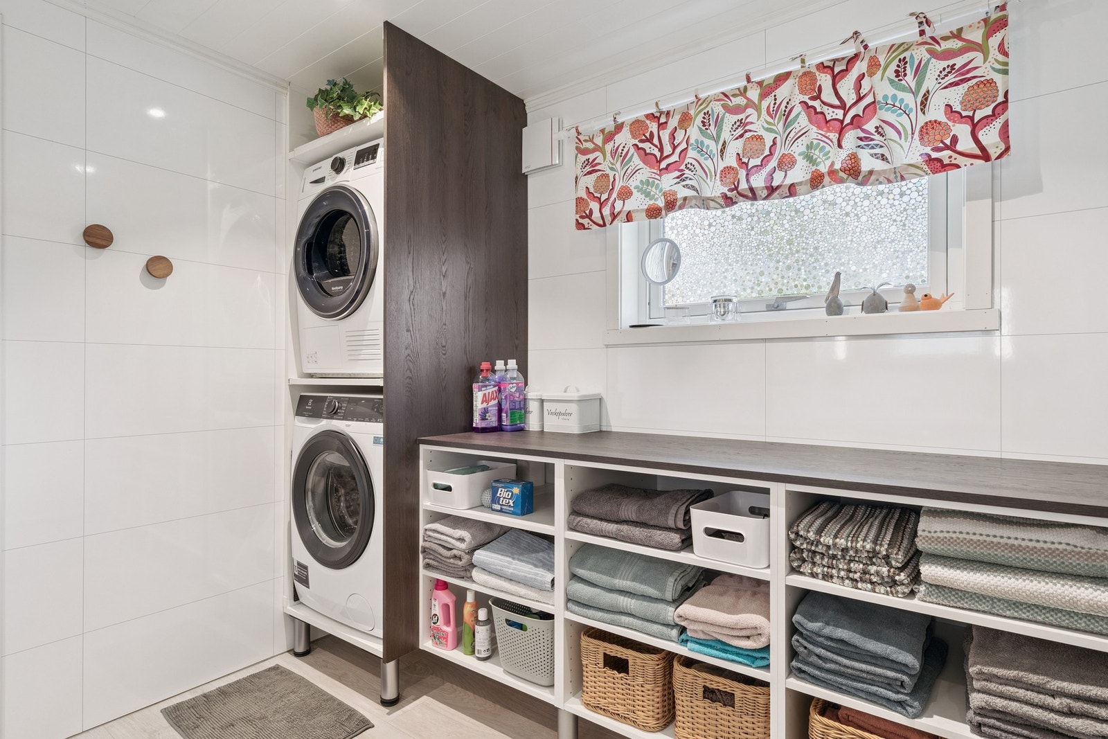 Praktisk vaskeromsnisje med hvitevarene i arbeidshøyde og smart hyllesystem. Galleribilde