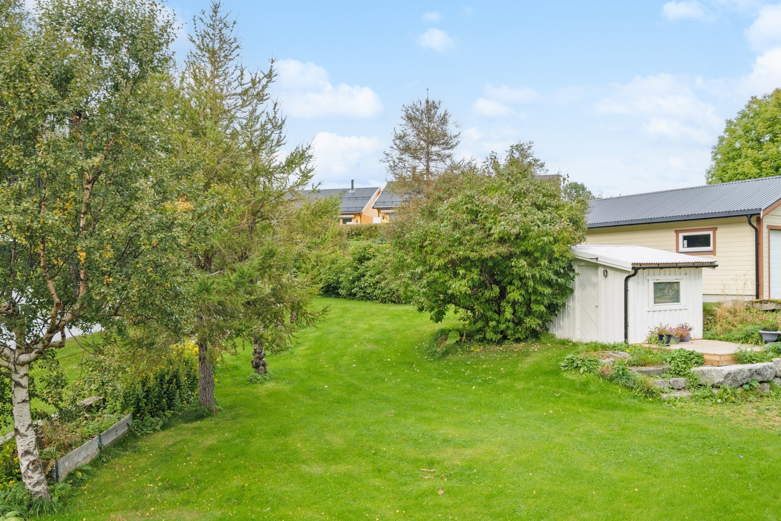 Solrik hage med god plass til lek og aktiviteter. Skjermet uteområde med grønne omgivelser og praktisk bod. Galleribilde