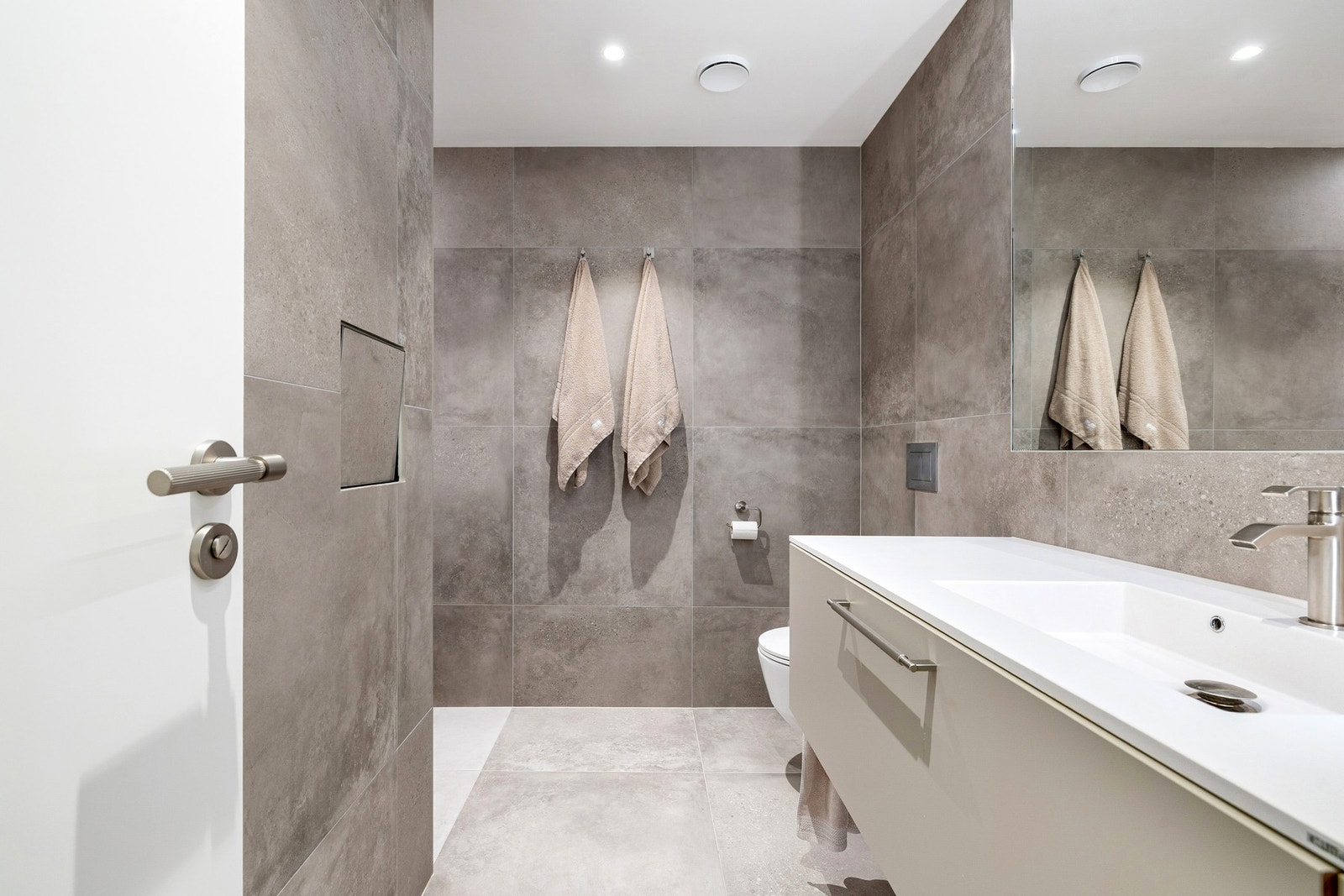 Moderne og helfliset bad på 5 kvm med gulvvarme, downlights i himling. Galleribilde