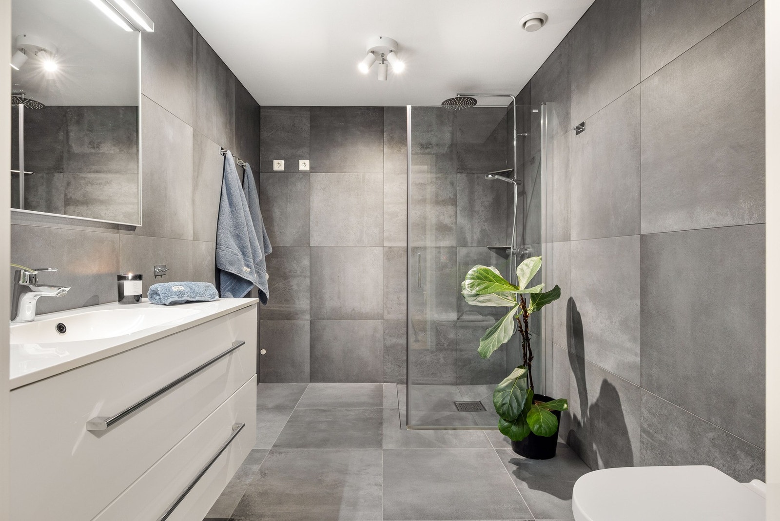 Delikat, flislagt baderom i ekslusivt design med stor dusj, innredning med nedfelt servant og vegghengt toalett. Badet har direkte adkomst fra hovedsoverom. Galleribilde