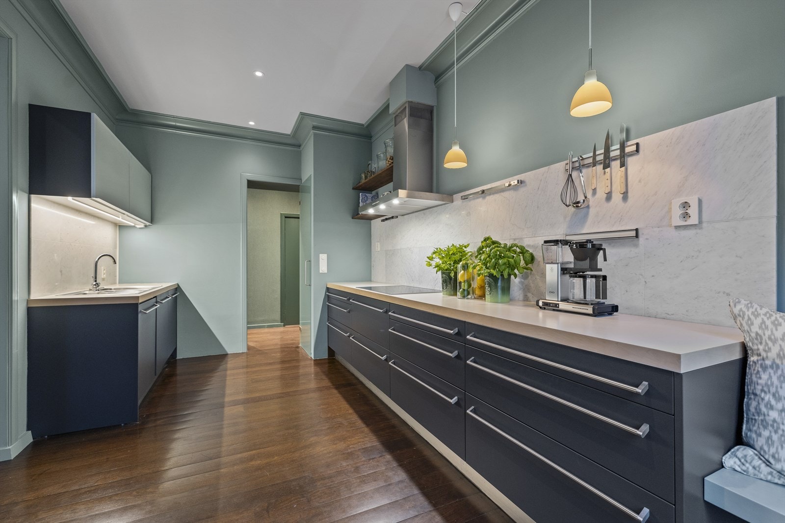 Kjøkkenet har sorte glatte fronter, ventilator med kullfilter. Galleribilde