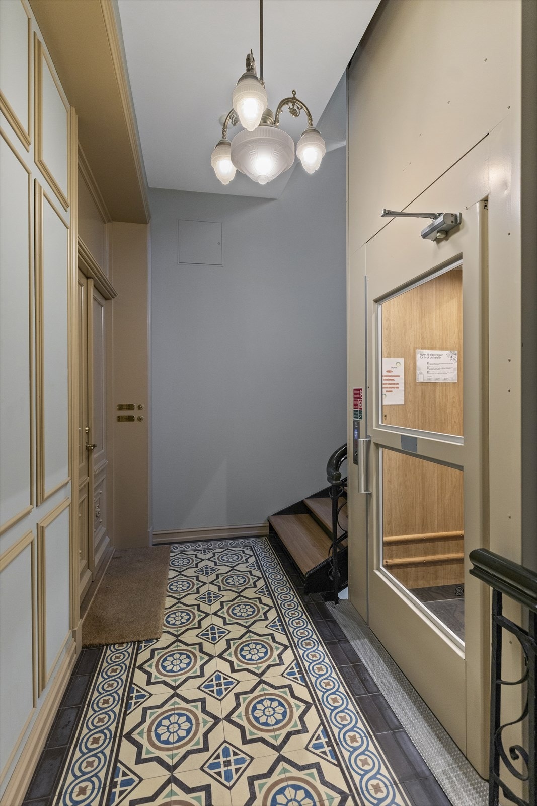 Pen oppgang med historiske gulvfliser. Det er heis i bygget. Galleribilde