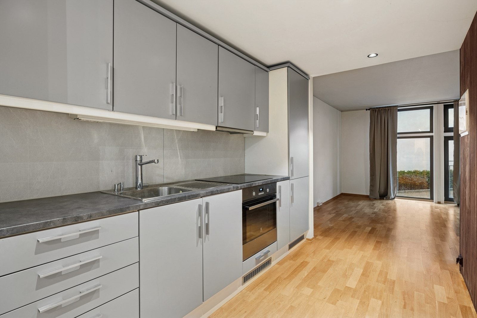 Kjøkkenet har slette fronter og laminat benkeplate. Det er integrert komfyr, platetopp og kjøl/fryseskap. Oppvaskmaskinen er underbygget og medfølger. Galleribilde