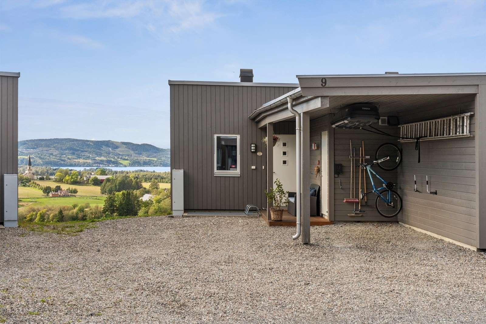 Det er godt med biloppstillingsplasser i egen caport og på egen gårdplass. Det er elbil-lader i carporten og en hyggelig velkomsplatting foran inngangsdøren og den praktiske sportsboden Galleribilde