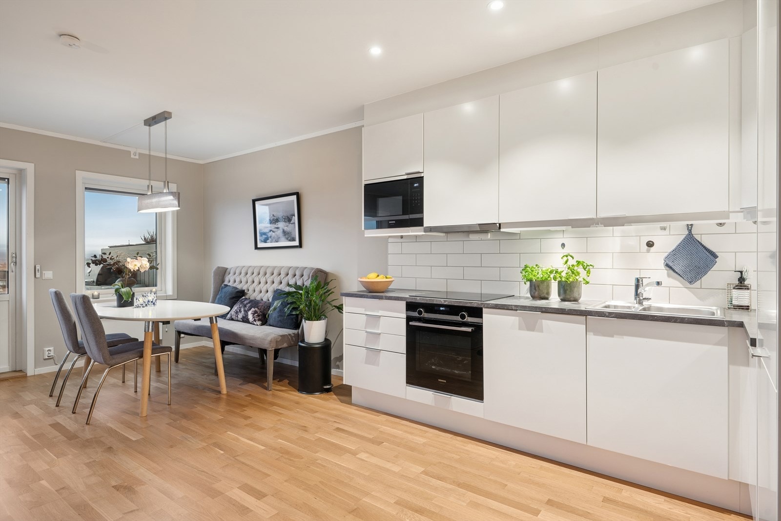 Kjøkkenet er praktisk utformet med takhøye skap som gir godt med oppbevaring Galleribilde