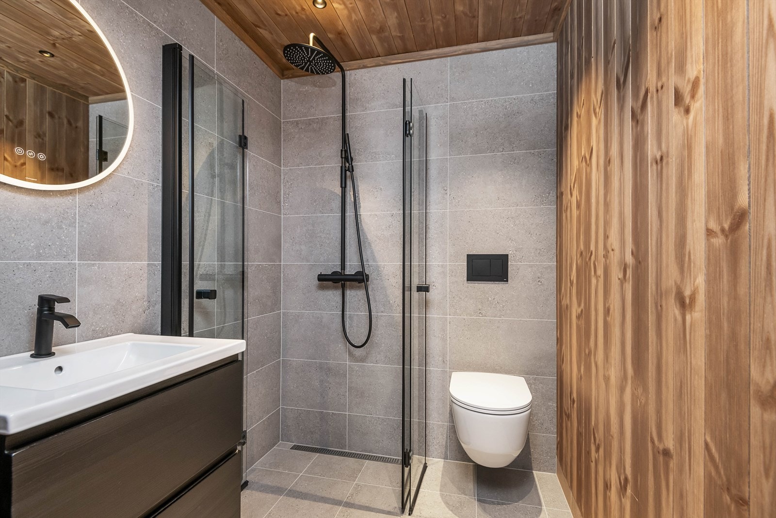 Delikat og tidløst bad/wc oppe i hovedetasjen har vegghengt wc, servantinnredning med skuffer for oppbevaring og dusj med glassvegger. Galleribilde