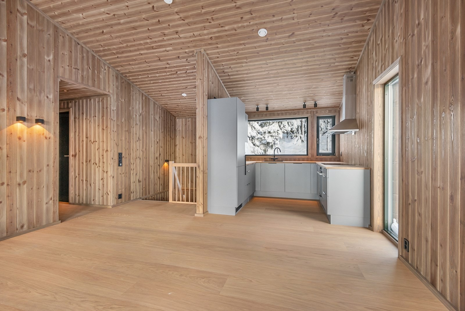 Innredningen på kjøkkenet er moderne, funksjonell og tidløs. Det er valgt en lys grå og delikat fargetone som står godt til de lune veggene. Galleribilde