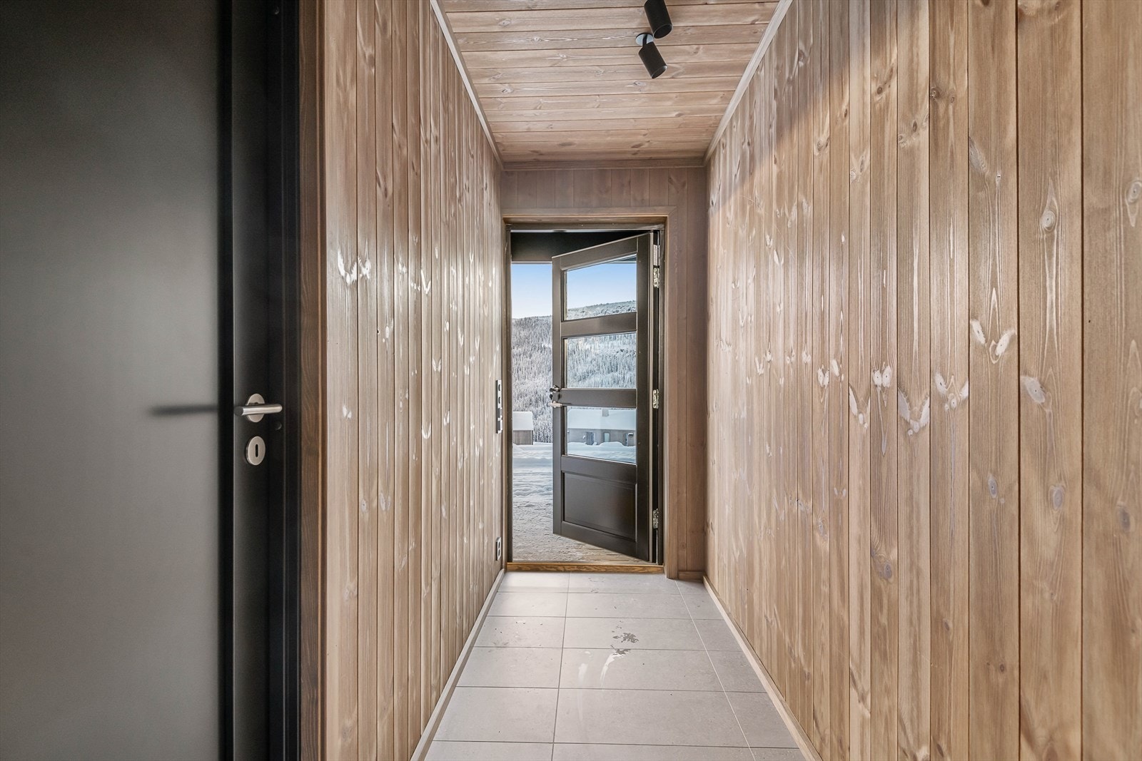 Hovedinngangen er fra bakkeplan og inn i underetasjen. Flislagte gulv med varmekabler. Galleribilde