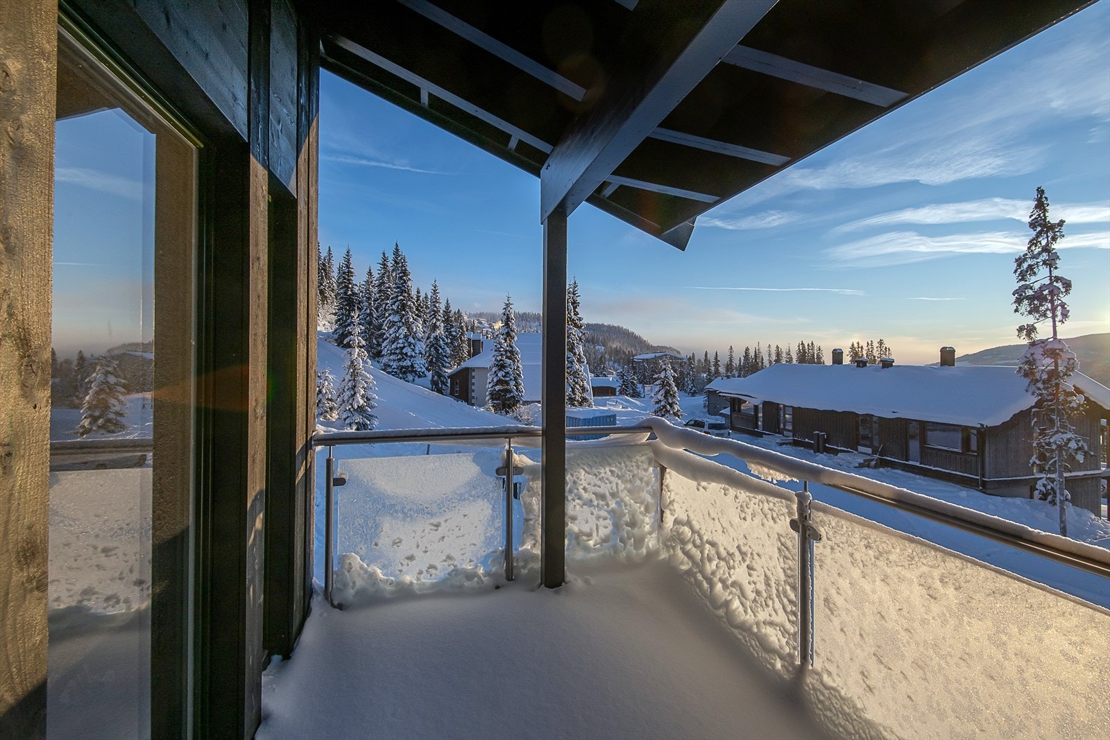 Overbygget balkong med glassrekkverk utenfor stua. Galleribilde