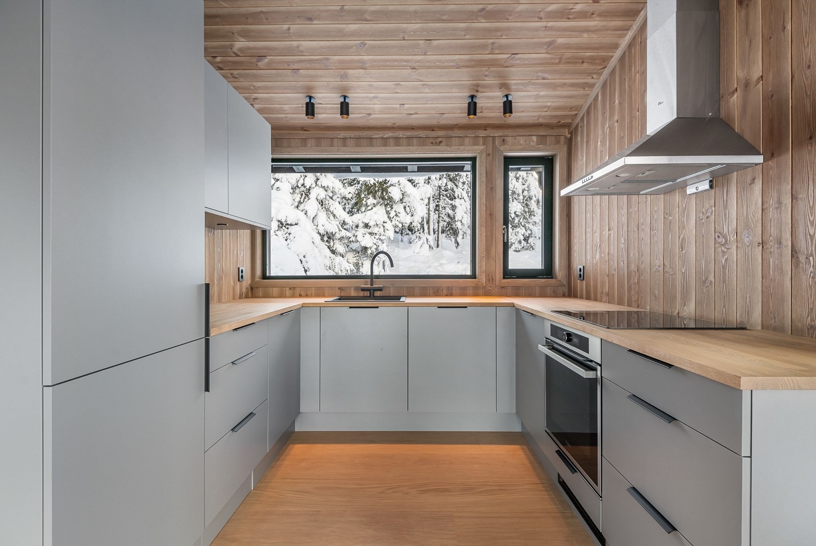 Kjøkkenet er i en U-form og har integrerte hvitevarer. Avtrekk over komfyr. Godt med oppbevaringsplass. Naturen kommer tett på, gjennom vinduet over kjøkkenbenken. Galleribilde