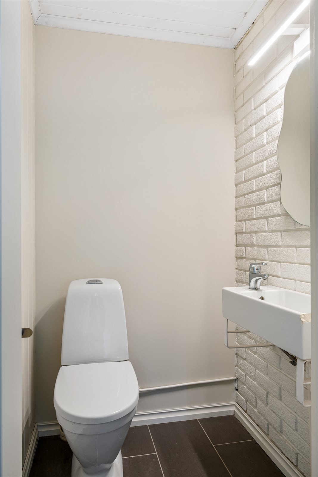 Toalettrom innredet med servant, speil og toalett. Galleribilde