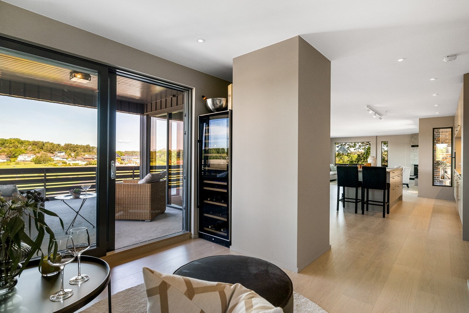 Stuen er fint inndelt i flere soner. En av de mest sjarmerende plassene er området rett ved terrassedøren - et perfekt sted for en god lenestol hvor man kan nyte et godt glass vin fra vinskapet med App styring av vinkjelleren din Galleribilde