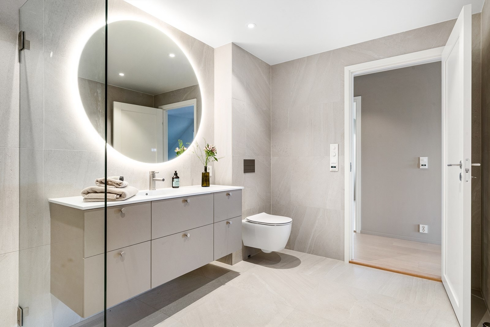 Det vegghengte klosettet bidrar til et moderne og luftig uttrykk, og den romslige dusjsonen har dusjnisje med glassvegg som gir et eksklusivt preg. Galleribilde