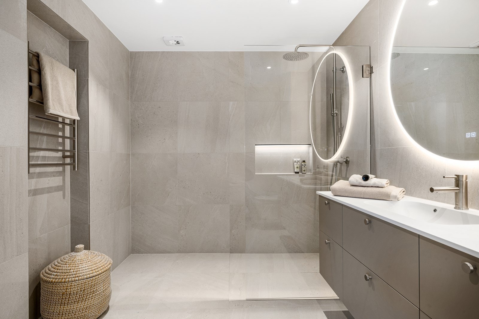 Rommet er delikat innredet med stilren baderomsinnredning med nedfelt servant og praktisk oppbevaringsplass. Galleribilde