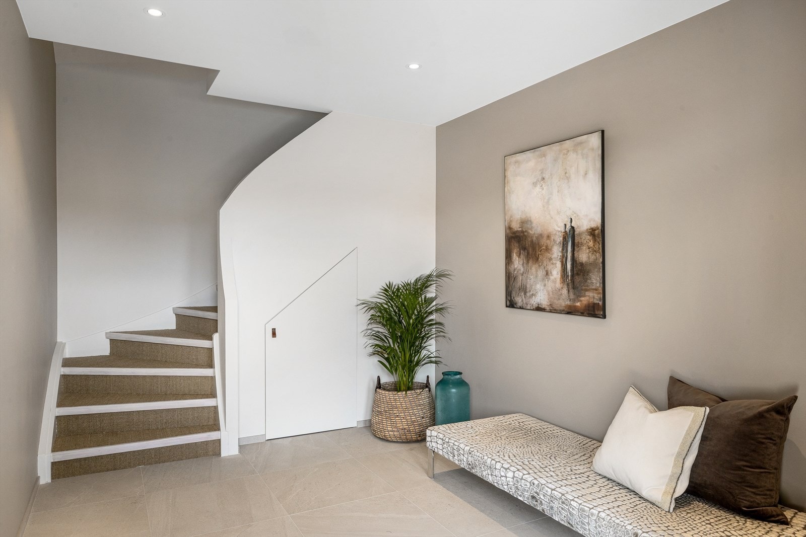 En lekker trapp fører deg ned til en innbydende entré med stilrene detaljer og gjennomført uttrykk. Galleribilde