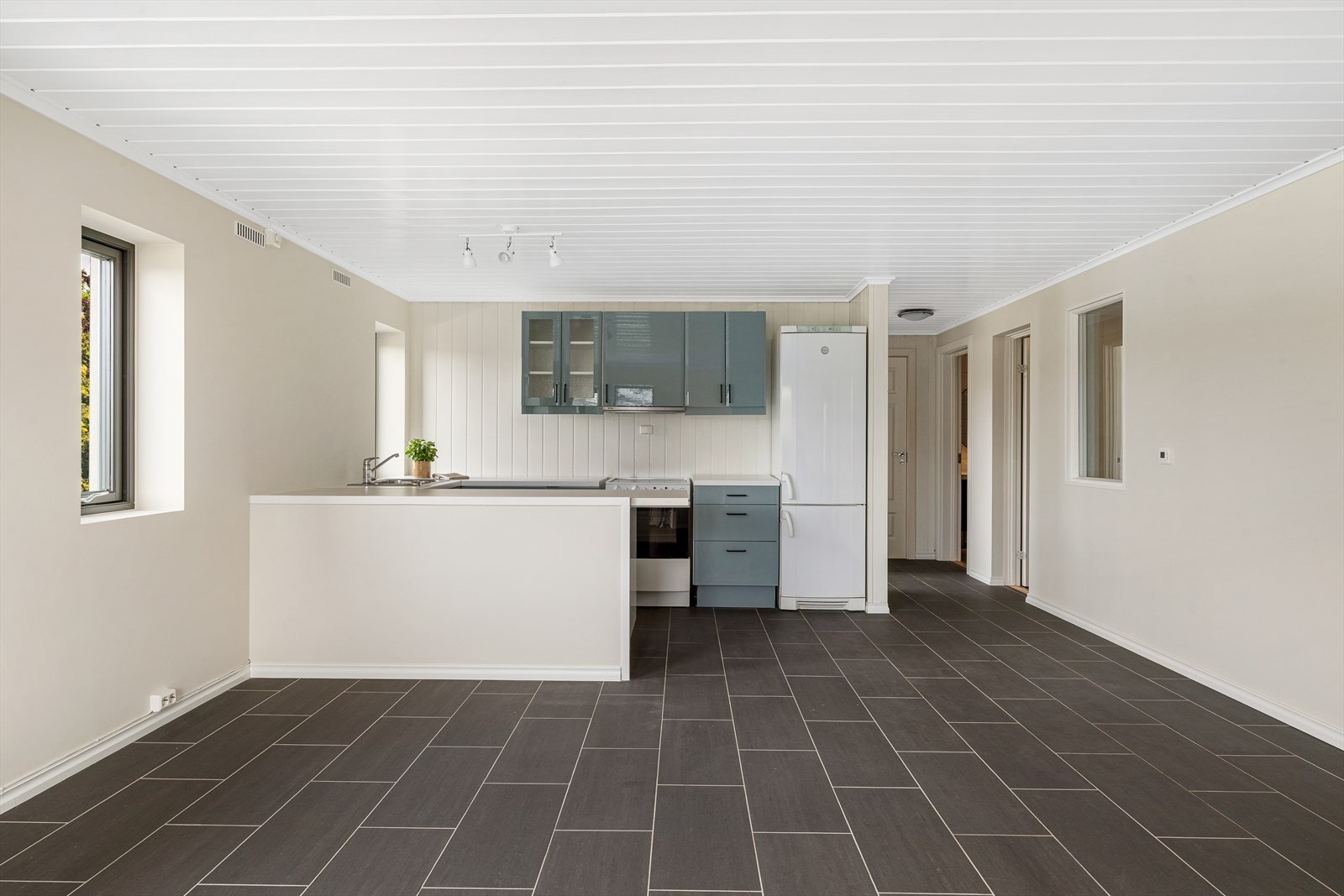 Kjøkkenet i leiligheten er funksjonelt innredet med glatte fronter og en laminat benkeplate med nedfelt oppvaskkum. Her er det godt med benk- og skapplass som gjør matlagingen både praktisk og oversiktlig. Galleribilde