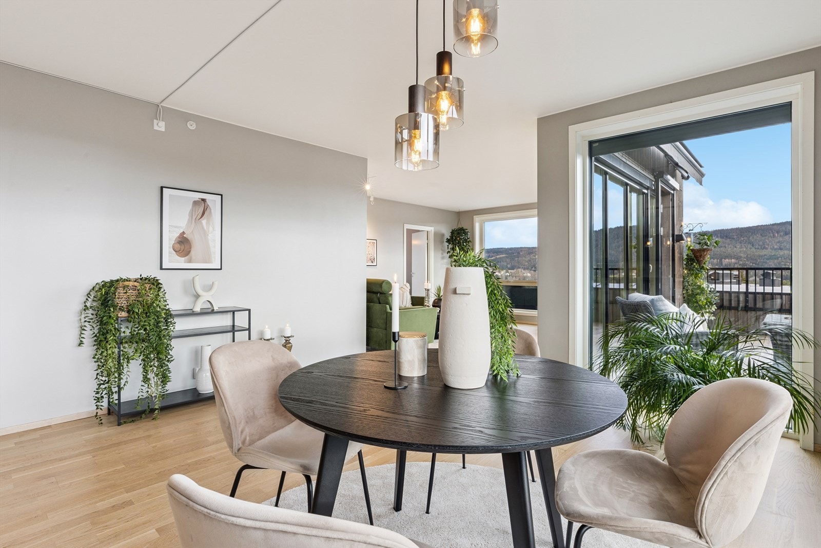 Spisestuen har fått sin naturlige plass midt i rommet, og fungerer som et innbydende samlingspunkt for både hverdagsmåltider og sosiale sammenkomster. Galleribilde