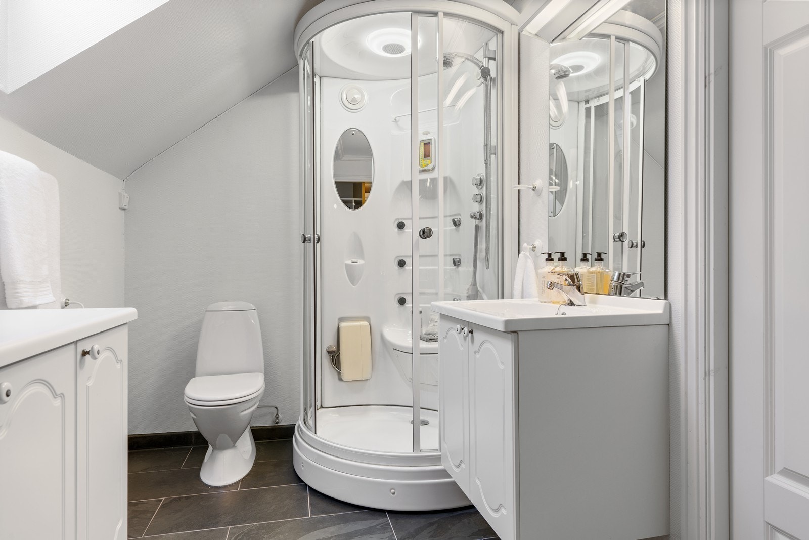 Baderom med fliser på gulv med varmekabler i og dusjkabinett. Galleribilde